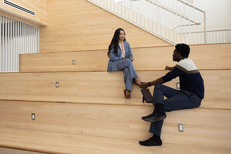 two people seated on steps and conversing