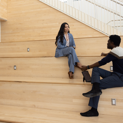 two people seated on steps and conversing