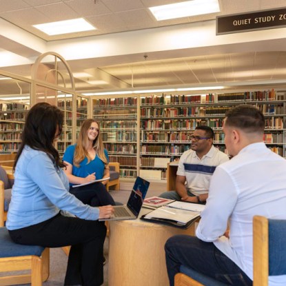 a group of people sitting at a table in a library