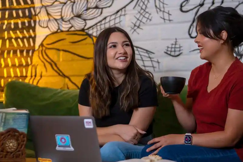 Two New Mexico State University students chatting in a coffeehouse — NMSU Global Campus