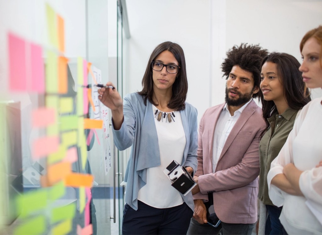 Office coworkers collaborate on a whiteboard