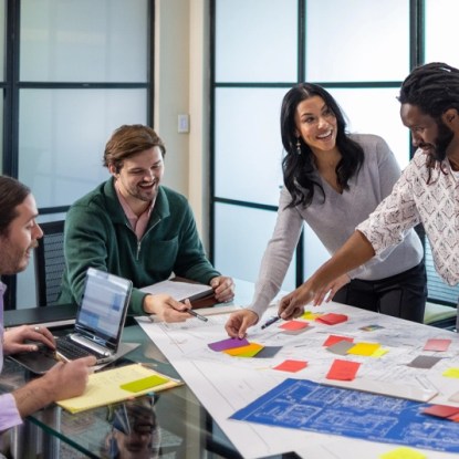 Four cheerful coworkers collaborate in a conference room