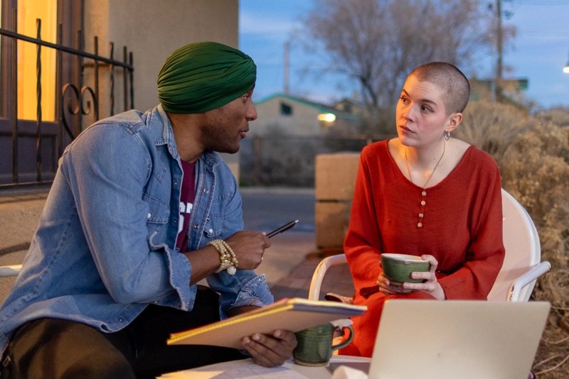 a man and a woman sitting at a table having an intellectual discussion