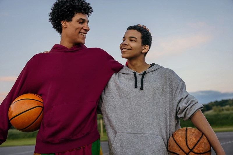 a couple of young men holding basketballs