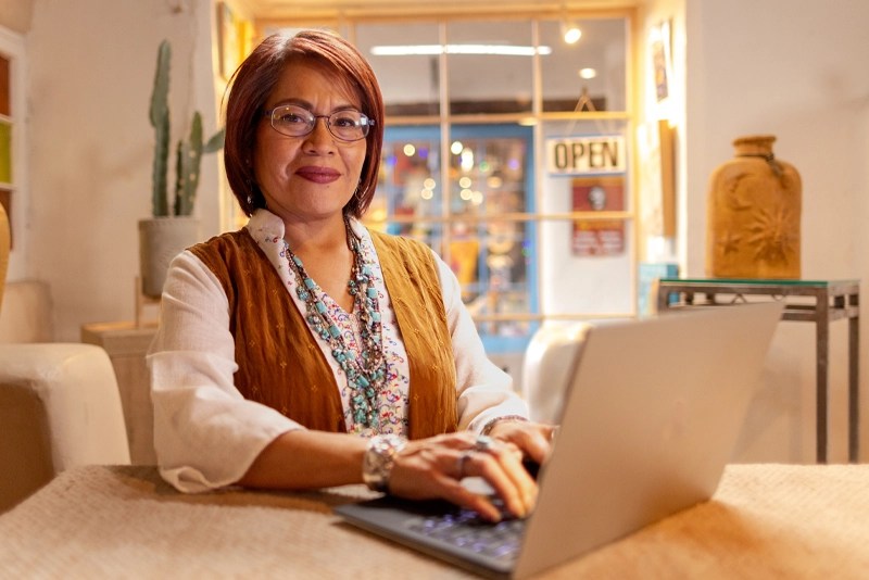 A woman sitting at a table with a laptop