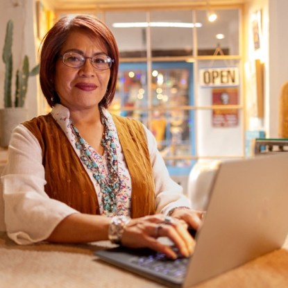 A woman sitting at a table with a laptop