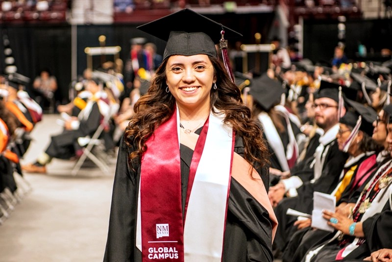 An NMSU Global Campus student in her graduation regalia