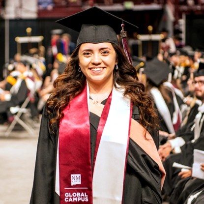 An NMSU Global Campus student in her graduation regalia