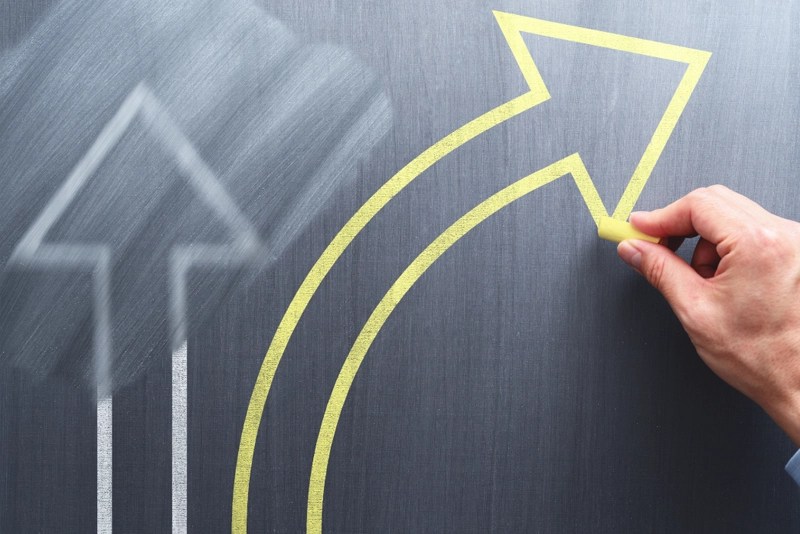 Decorative image of a hand drawing arrows on a chalkboard