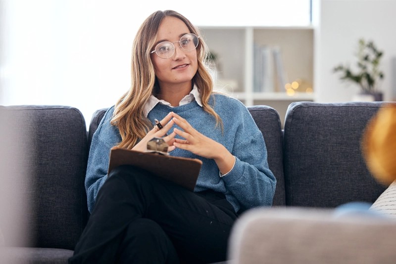 A mental health professional takes notes during a counseling session