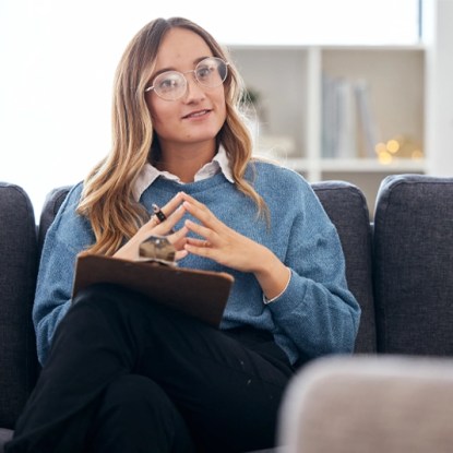 A mental health professional takes notes during a counseling session