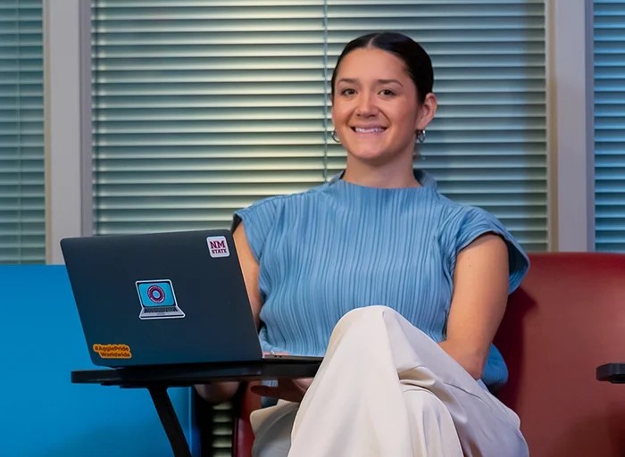 Woman smiling with laptop at NMSU Global Campus — online Bachelor of Arts in Psychology degree program