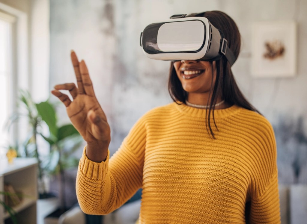 A woman wearing VR glasses for a plugged in emerging tech microlearning course at NMSU Global Campus