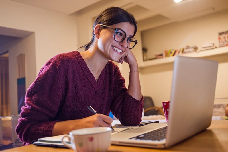A student at New Mexico State University Global Campus interacts with her online class via laptop