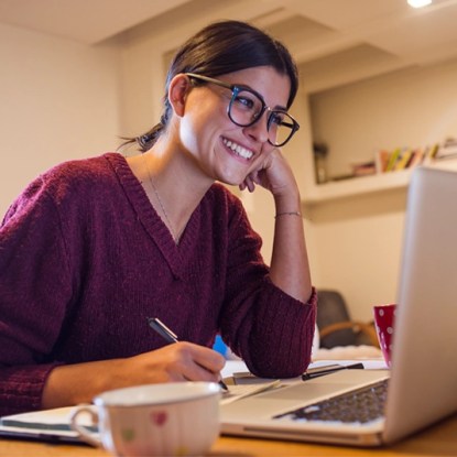A student at New Mexico State University Global Campus interacts with her online class via laptop