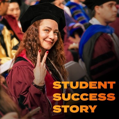 A woman in graduation clothing holds up two fingers to make a peace sign — NMSU Global Campus commencement ceremony