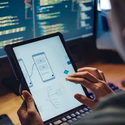 Person designing a mobile app interface with code — NMSU Global Campus