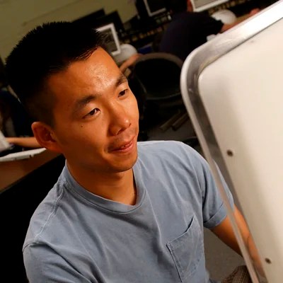 An online student works on a desktop computer — NMSU Global Campus microlearning courses for working professionals