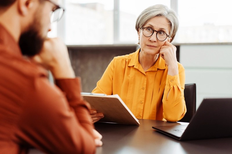 A therapist listens to her client with a look of concern