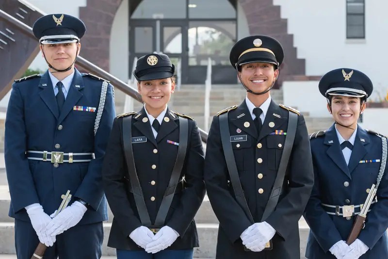 Four young men and women pose in military uniforms
