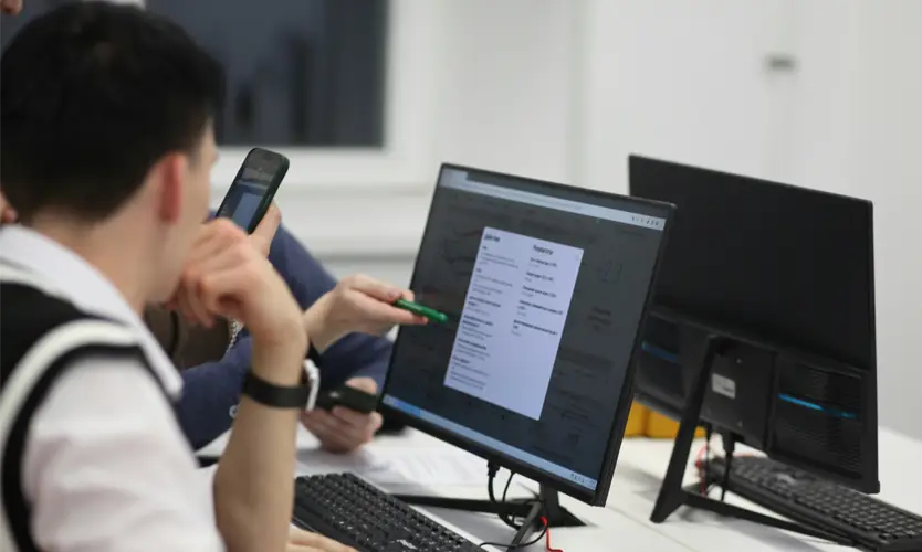 An communications office worker sits at a computer monitor