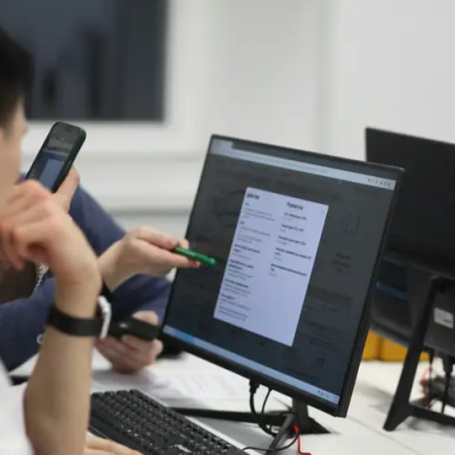 An communications office worker sits at a computer monitor