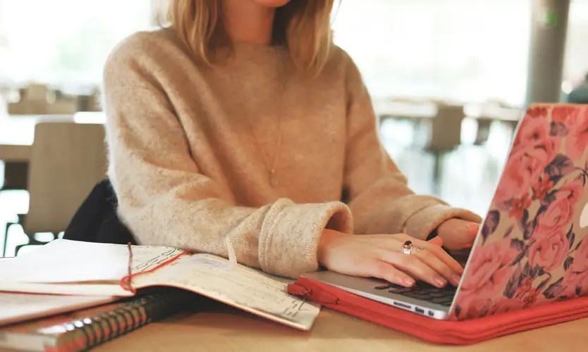 A woman typing on a laptop computer