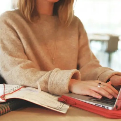 A woman typing on a laptop computer