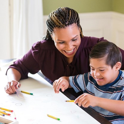 A special education teacher working with a cheerful child