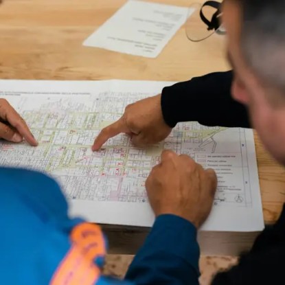 Two engineers examining technical documentation