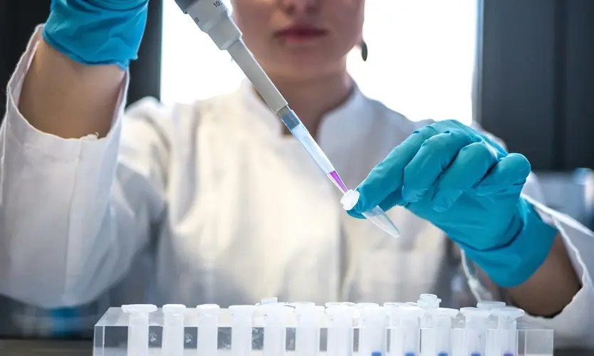 Public health researcher using a pipette to analyze laboratory samples