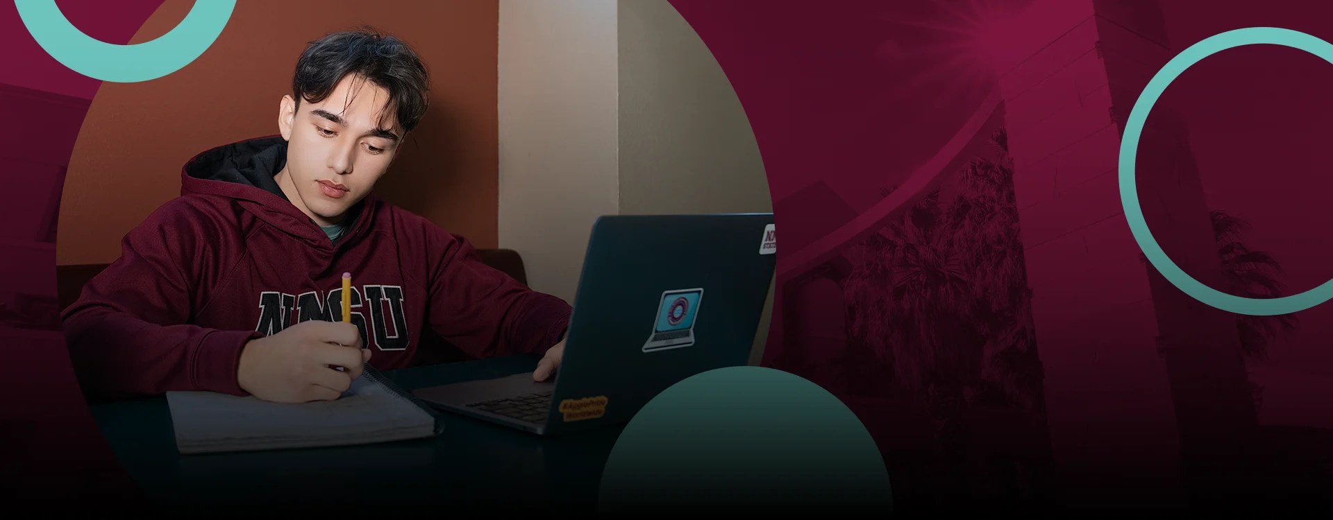An NMSU student working with a laptop and a pencil