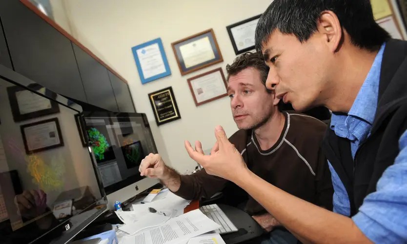 Two NMSU professors looking at a computer monitor together