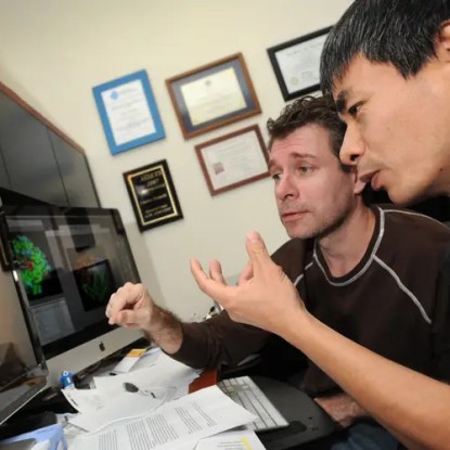 Two NMSU professors looking at a computer monitor together